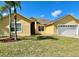 Charming single-story home featuring a well-manicured lawn and a two-car garage at 434 Acacia Tree Way, Kissimmee, FL 34758