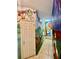 Hallway with incredible custom Disney-themed wall murals and tile floors at 434 Acacia Tree Way, Kissimmee, FL 34758