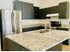 Modern kitchen featuring granite countertops, stainless steel appliances, and sleek, dark cabinetry at 434 Acacia Tree Way, Kissimmee, FL 34758