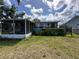 Backyard with the home's enclosed patio and a partial fence for added privacy at 55808 Nan Dr, Astor, FL 32102