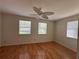 Bright bedroom with wood floors, a ceiling fan, and two windows letting in natural light at 55808 Nan Dr, Astor, FL 32102