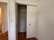 Bedroom closet with wood flooring, shelving, and white folding doors at 55808 Nan Dr, Astor, FL 32102