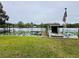 Scenic waterfront featuring a dock, boat, and lush water lilies, perfect for enjoying lakeside living at 55808 Nan Dr, Astor, FL 32102