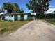 Exterior of the residence, featuring a gravel driveway and partial waterfront view at 55808 Nan Dr, Astor, FL 32102