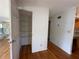 Hallway featuring an open closet with multiple shelves and wood flooring throughout at 55808 Nan Dr, Astor, FL 32102