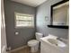 Powder room featuring a window, neutral walls, a vanity, and a toilet at 55808 Nan Dr, Astor, FL 32102