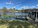 Scenic waterfront view featuring a private dock, boat house, and serene water lilies at 55808 Nan Dr, Astor, FL 32102