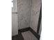 Shower with marble-look tile and dark wood accents at 645 Cherry St, Daytona Beach, FL 32114