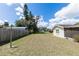 A spacious and grassy backyard featuring mature trees and a partial fence at 708 Wynn Dr, Sanford, FL 32773