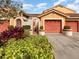 Front view of condo building with two-car garage and landscaping at 7654 Sugar Bend Dr # 7654, Orlando, FL 32819