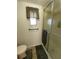 Toilet and shower featuring a shower door and neutral tile flooring at 103 Bougainvillea Dr, Leesburg, FL 34748