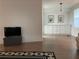 Living room with wood-look flooring, gray ottoman, flat screen TV, and dining room view at 103 Bougainvillea Dr, Leesburg, FL 34748