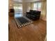Living room features wood-look flooring, area rug, furniture, and sliding door to sun room at 103 Bougainvillea Dr, Leesburg, FL 34748