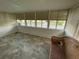 Relaxing sun room with wall to wall windows and a wicker loveseat at 103 Bougainvillea Dr, Leesburg, FL 34748