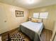 Bright bedroom featuring stylish decor, wood-look walls and a decorative rug at 106 Royal Palm Dr, Leesburg, FL 34748