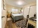 Cozy bedroom featuring a comfortable bed, a black and white rug and a bright workspace at 106 Royal Palm Dr, Leesburg, FL 34748