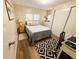 Cozy bedroom featuring a comfortable bed, a black and white rug and a bright workspace at 106 Royal Palm Dr, Leesburg, FL 34748