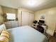 Comfortable bedroom with neutral tones, a sliding closet, and a dedicated desk area at 106 Royal Palm Dr, Leesburg, FL 34748