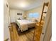 Bright bedroom with bed and wood floors; door leads to ensuite bathroom at 106 Royal Palm Dr, Leesburg, FL 34748