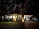 Charming home with a well-lit driveway, lush greenery, and a covered parking area at 106 Royal Palm Dr, Leesburg, FL 34748