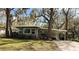 Charming single story home featuring mature landscaping and a convenient covered parking area at 106 Royal Palm Dr, Leesburg, FL 34748