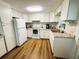 Bright kitchen with white cabinets, stainless steel appliances, and hardwood floors at 106 Royal Palm Dr, Leesburg, FL 34748