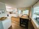 Kitchen featuring white cabinets, wood-look floors, stainless appliances, and breakfast bar at 106 Royal Palm Dr, Leesburg, FL 34748