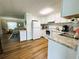 Bright kitchen with white cabinets, stainless steel appliances, and hardwood floors at 106 Royal Palm Dr, Leesburg, FL 34748