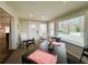 Sunny enclosed porch with tiled floors, table, and wicker furniture offers extra living space at 106 Royal Palm Dr, Leesburg, FL 34748