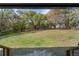 View of large backyard with outbuildings and mature trees from covered porch at 1107 Linmar Ave, Fruitland Park, FL 34731