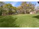 Large backyard with mature trees and green grass, ideal for outdoor activities at 1107 Linmar Ave, Fruitland Park, FL 34731