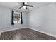 Bedroom with wood-look floors, blue walls, ceiling fan, and window with blue curtains at 1107 Linmar Ave, Fruitland Park, FL 34731