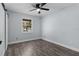 Bedroom with wood-look floors, ceiling fan, window, and sliding barn door at 1107 Linmar Ave, Fruitland Park, FL 34731