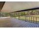 Spacious covered deck with wood floors and railings, perfect for enjoying the outdoors at 1107 Linmar Ave, Fruitland Park, FL 34731