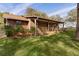 Single-story home featuring natural wood siding, cozy front porch, and mature trees on an expansive leafy green lot at 1107 Linmar Ave, Fruitland Park, FL 34731