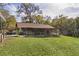 View of the side of the house showcasing the back porch and surrounding green yard at 1107 Linmar Ave, Fruitland Park, FL 34731