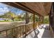 Spacious covered front porch with wood railing, offering an inviting outdoor living space and views of the leafy yard at 1107 Linmar Ave, Fruitland Park, FL 34731