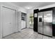 Kitchen with stainless steel refrigerator, white tile floors, and washer dryer at 1107 Linmar Ave, Fruitland Park, FL 34731