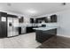 Spacious kitchen with stainless steel refrigerator, a breakfast bar, and black cabinetry at 1107 Linmar Ave, Fruitland Park, FL 34731