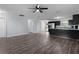 Living room with wood-look flooring, neutral walls, ceiling fan, and windows for natural light at 1107 Linmar Ave, Fruitland Park, FL 34731