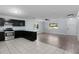 Living room and kitchen with tile and wood-look floors, neutral walls and window views at 1107 Linmar Ave, Fruitland Park, FL 34731