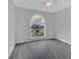 A bright bedroom with hardwood floors, neutral walls, and arched window at 1134 Norwood Dr, Deltona, FL 32725