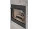 Close-up of a modern fireplace with logs, showcasing the texture of the stone surround at 1134 Norwood Dr, Deltona, FL 32725