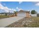 Single-story home with an attached garage, manicured landscaping and a long driveway leading to the house at 1134 Norwood Dr, Deltona, FL 32725
