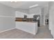 Kitchen features breakfast bar, white cabinets, stainless sink, and dark appliances at 1134 Norwood Dr, Deltona, FL 32725