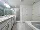Bright bathroom featuring double vanity, large mirror, glass shower, and separate tub at 1212 Caloosa Ridge Ave, Babson Park, FL 33827