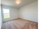 Neutral carpeted bedroom with a window offering a view of the outdoors at 1212 Caloosa Ridge Ave, Babson Park, FL 33827