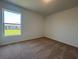 Neutral bedroom with carpeted floor and window view of backyard at 1212 Caloosa Ridge Ave, Babson Park, FL 33827