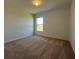 Carpeted bedroom featuring a window with an outdoor view and natural light at 1212 Caloosa Ridge Ave, Babson Park, FL 33827