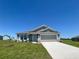 Charming single-story home featuring a gray exterior, stone accents, and a well-manicured lawn at 1212 Caloosa Ridge Ave, Babson Park, FL 33827